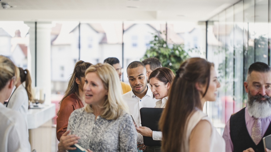 Work colleagues meeting and talking in corporate building