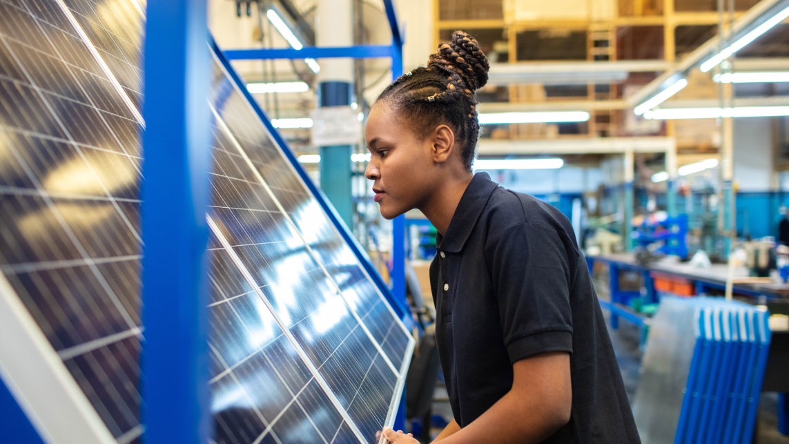 Quality engineer examining solar panels in factory