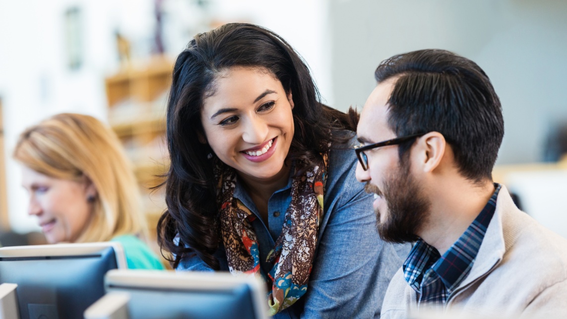 Friendly Hispanic woman talking with college classmate