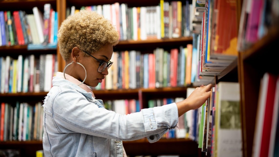 Student Choosing a Book on Library