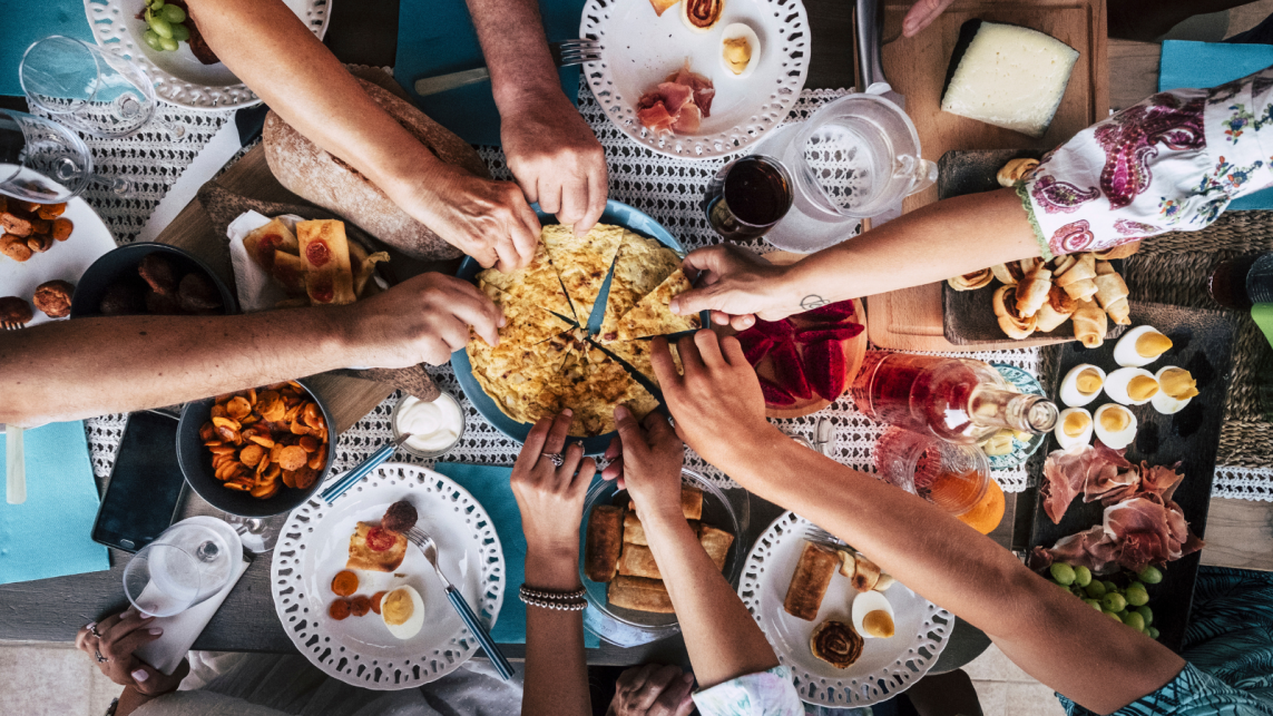 A restaurant table where 7 different your people are sharing food