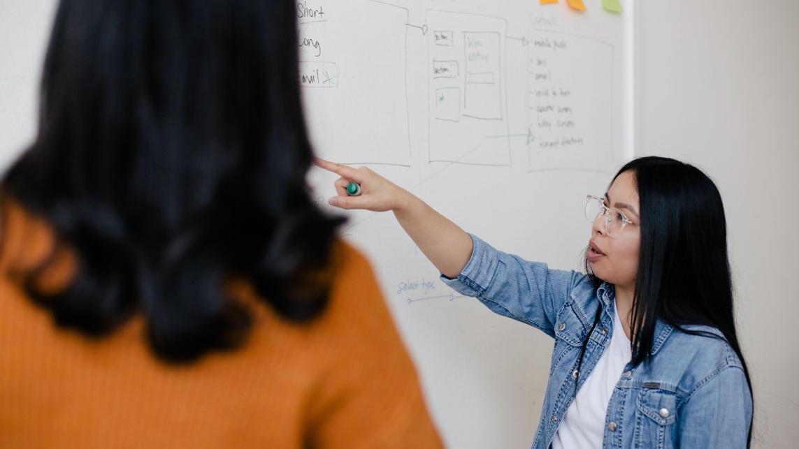 Person pointing at white board