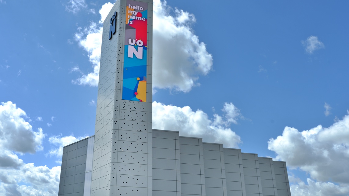 Image of the University of Northampton's Energy Centre at Waterside Campus, a large grey building against a backdrop of blue sky and white clouds