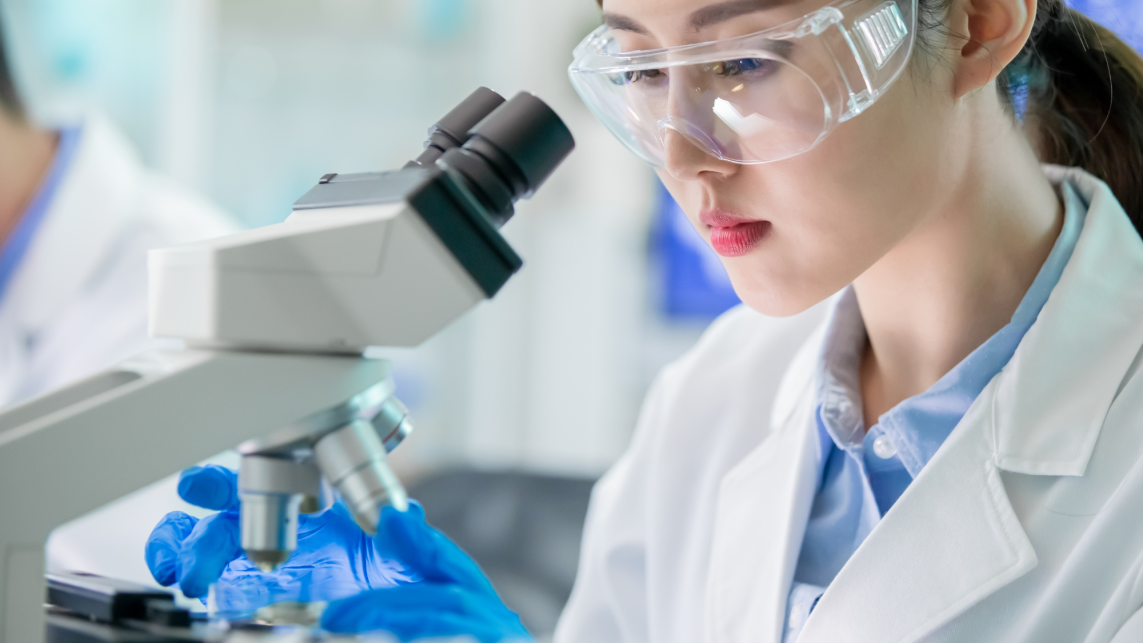 Postgraduate research science student using a microscope