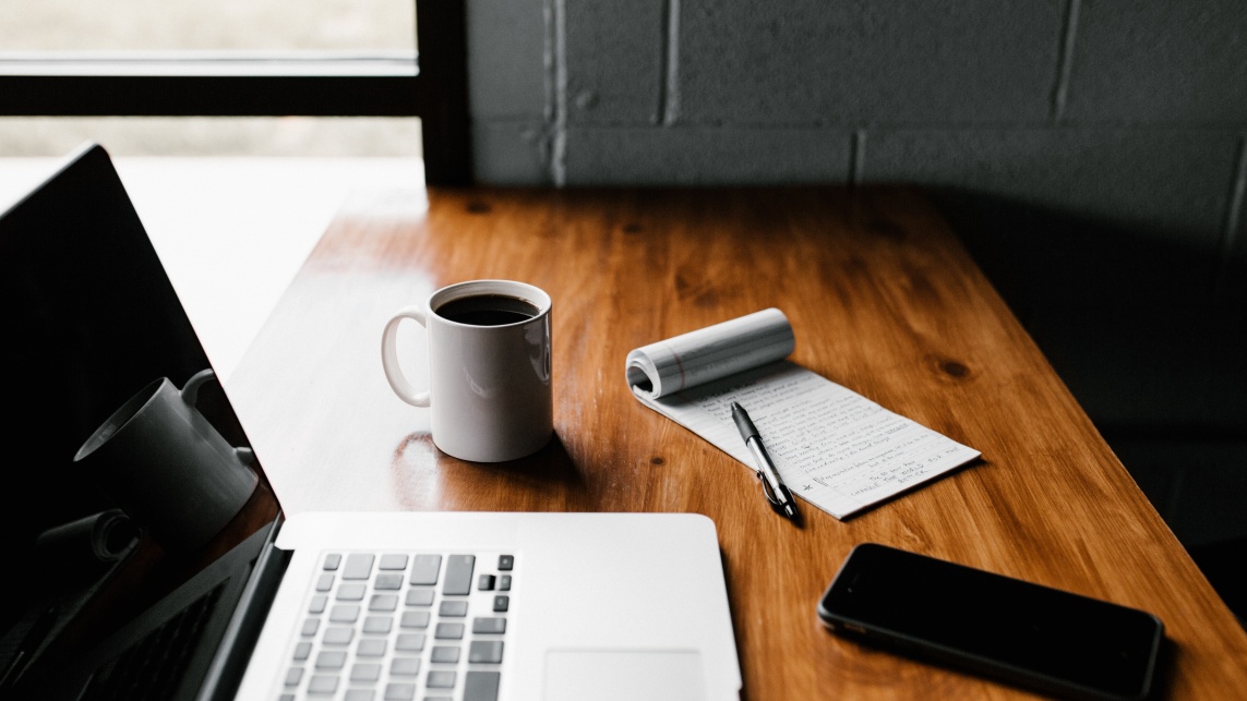 Laptop with mug and notepad