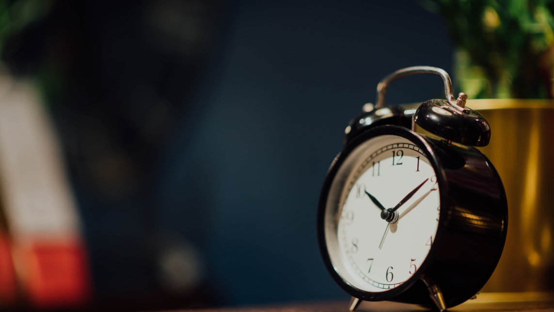 Image of an alarm clock on a bedside table