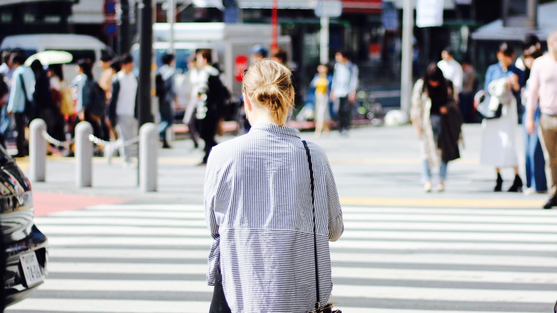 Woman standing at pedestrian crossing 