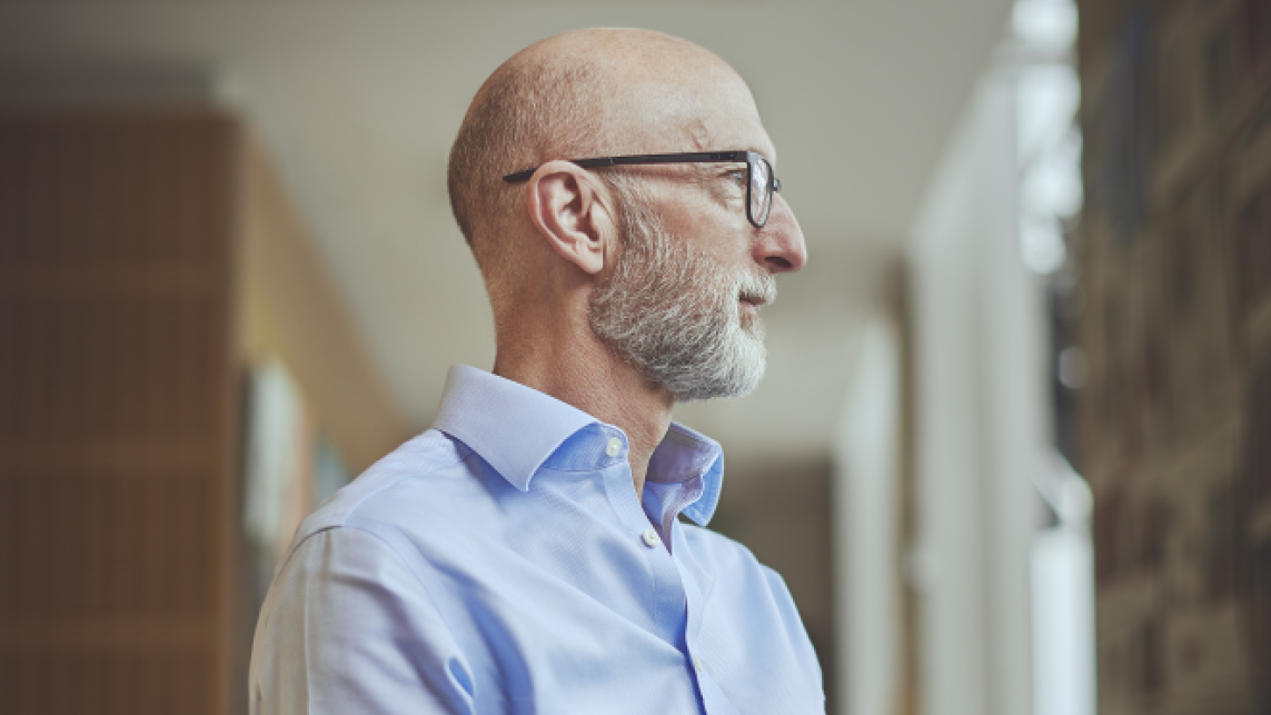 Professor Nic Beech in a university setting. The photo is taken from the side and he is looking ahead with a serious expression.