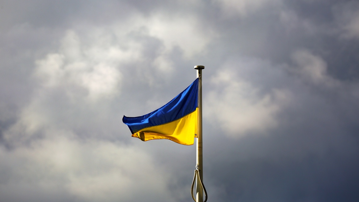 A ukraine flag against a grey sky