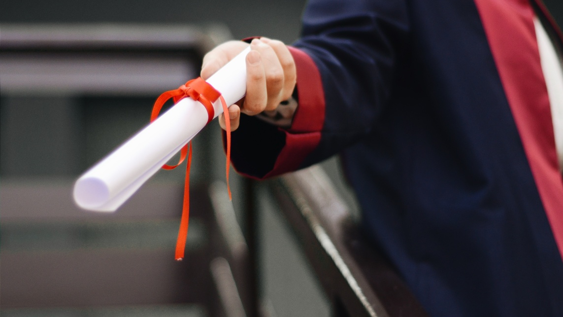 Person holding graduation certificate