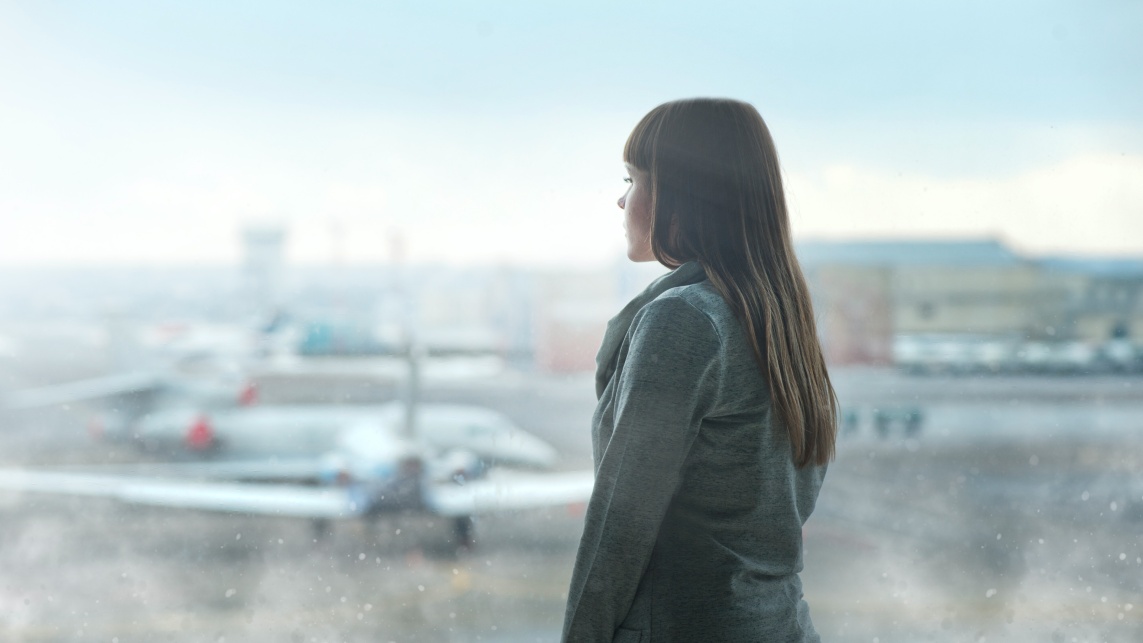 Woman looking outside the window at an airport