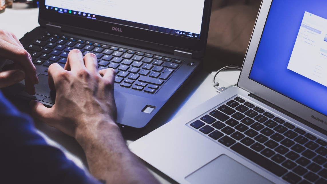 A person facing two laptop screens