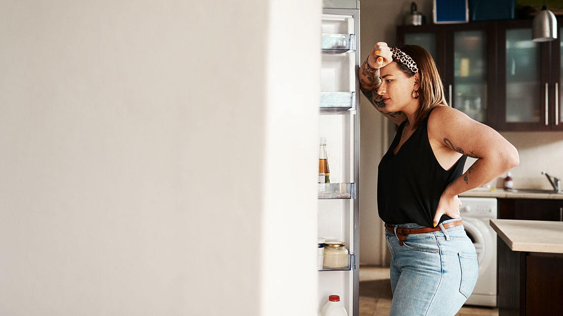 Student looking in fridge looking concerned