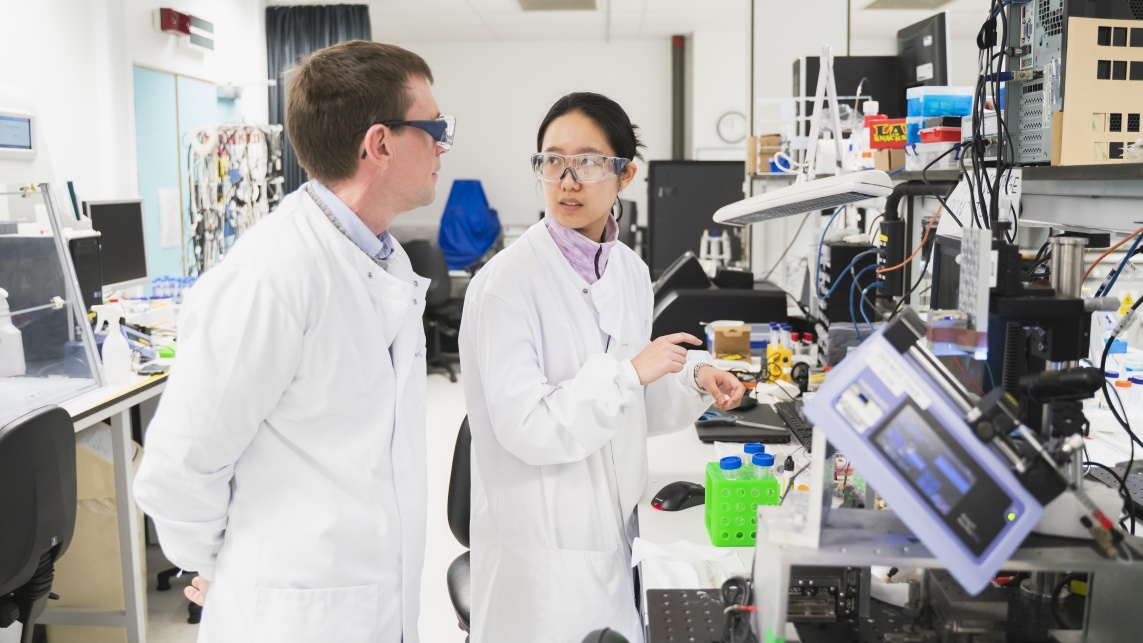 Two scientists in lab coats have a discussion