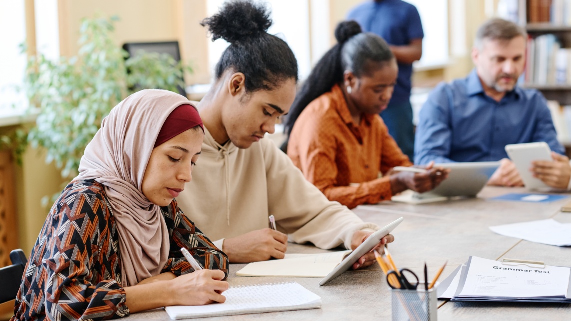 Students sitting at a desk working together.