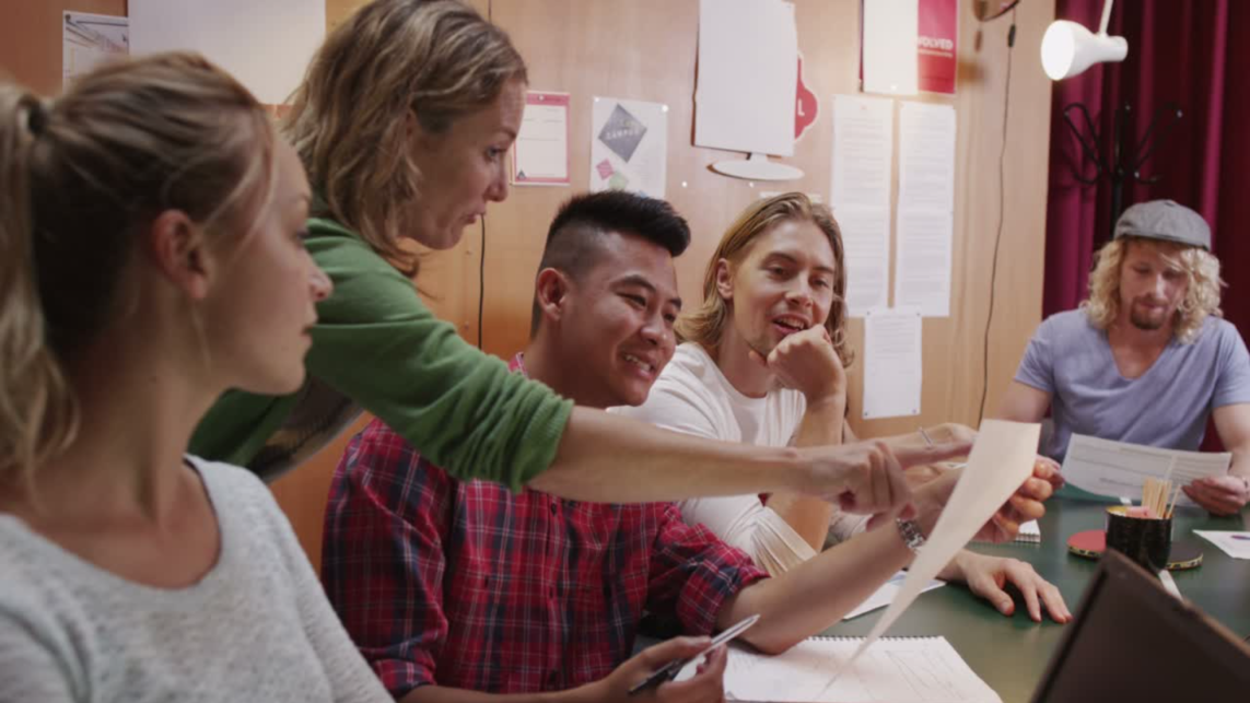 people collaborating in a team and focusing on a piece of paper