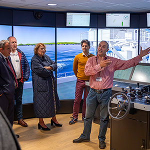 Plymouth University in a cyber security meeting. One individual is speaking to a crowd inside the Cyber-SHIP lab.