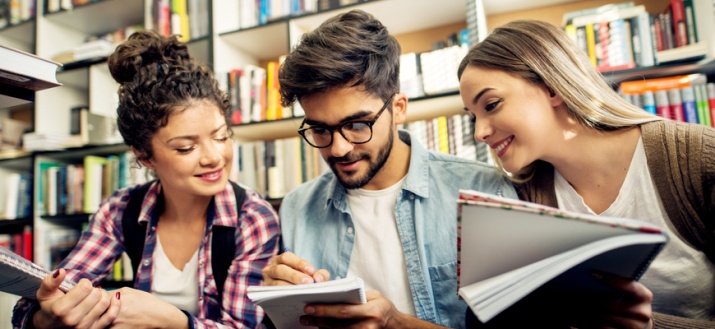 Three people looking at a notepad
