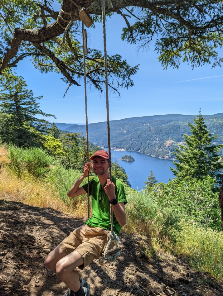 Alex sat on a swing in front of a scenic view