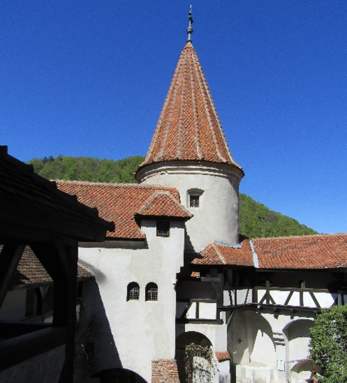 Bran Castle, Romania, with a blue sky in the background.