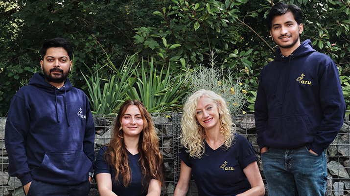 Anglican Ruskin University AREA team sitting and standing together in front of a garden. From left to right are team members: Omkar Singh, Cristina Ionita, Catherine Foottit, Abhinav Mayeekkara.