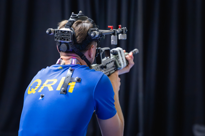 Man wearing head-mounted equipment and holding a firearm