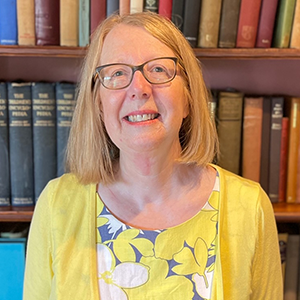 Fiona Waye in front of a bookshelf