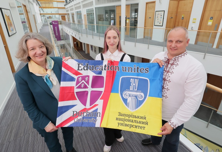 Staff on a visit to Durham from ZNU, holding a Union Jack - Ukraine unity flag