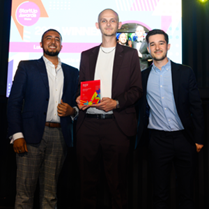 Lunia 3D co-founders stand in front of a presentation screen, holding a Start-Up Award.