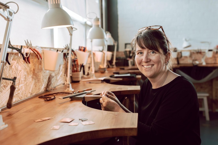 Heather Fox sitting in her studio, smiling at the camera