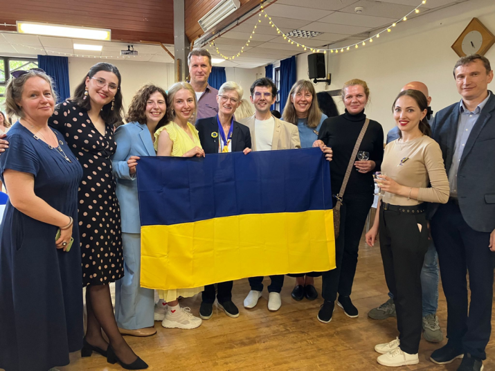 Ukrainian and Durham staff and students stand together, holding a Ukrainian flag