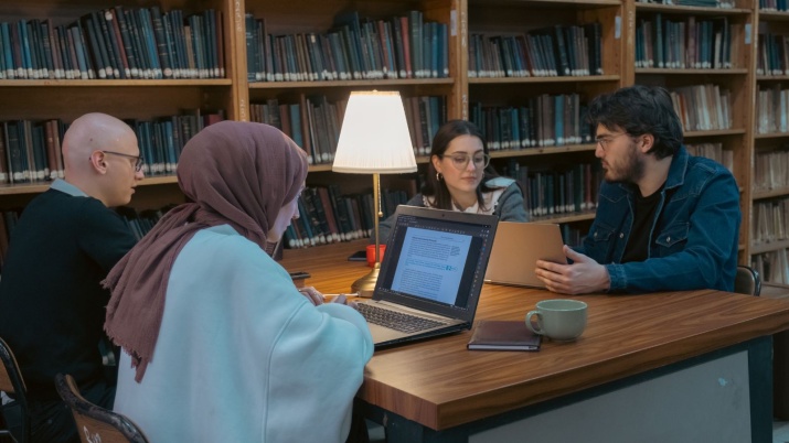 students sat a table studying in a library