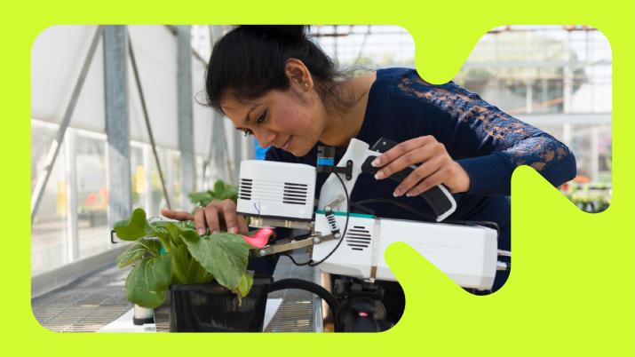 student examining plants with a scanning machine
