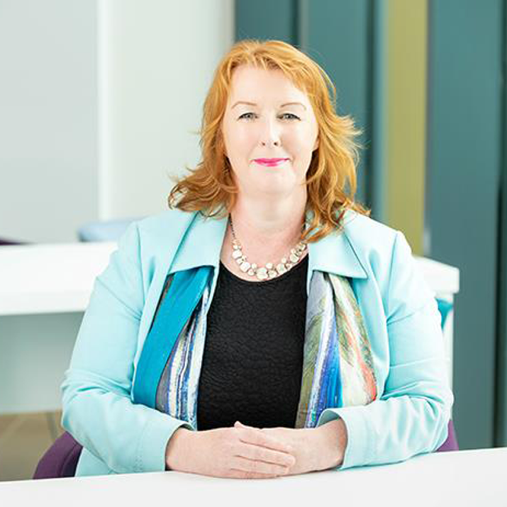 Vicki Nairn, Principal and Vice-Chancellor of University of the Highlands and Islands sits at a table with her hands together. Vicki wears a light blue blazer and black top.