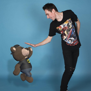 Waving Bear Studio co-founding&nbsp;director, Ashley Wharfe hi-fives an animated bear against a blue backdrop.