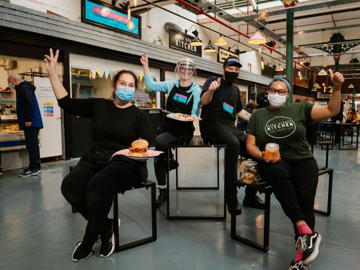 Park Street Kitchen employees, wearing face masks and visors, posing with their products in Wellington Market