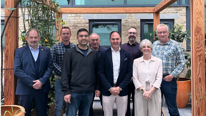 AdTechOptima team smiling in an outdoor area with plants