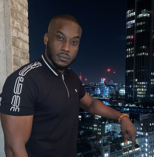 Bunmi standing on a balcony with a nighttime city view