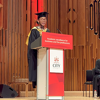 Carlene stands at the lectern on her graduation day 