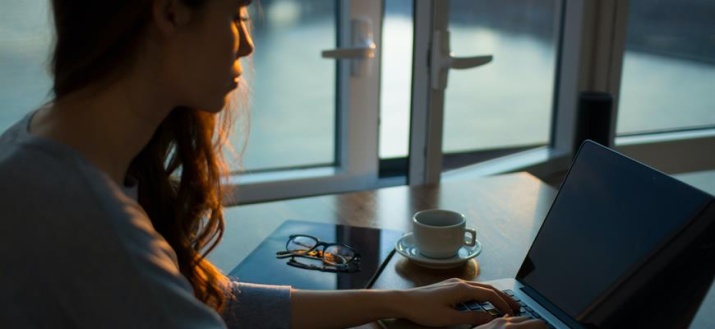 women sitting with an open laptop