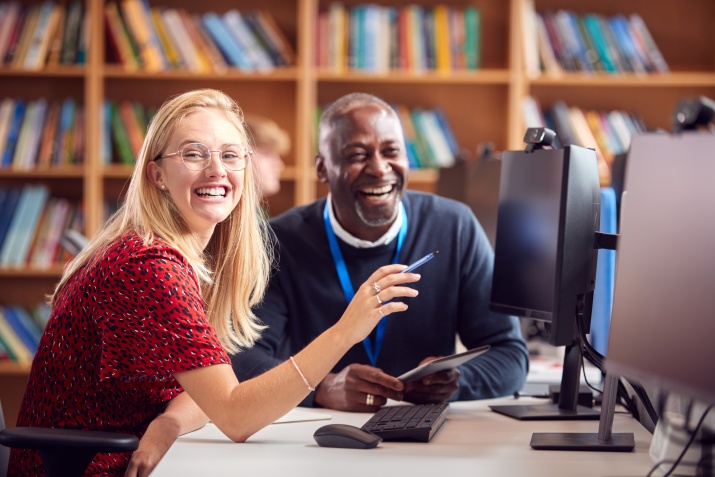 A woman and tutor sit together happily