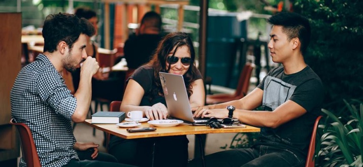 Three people having a coffee outside a cafe