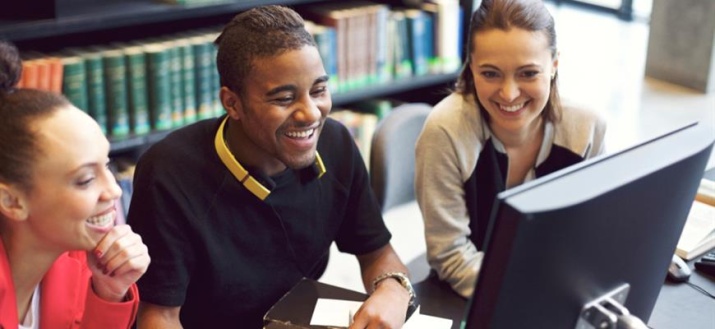 Three people looking at a computer screen
