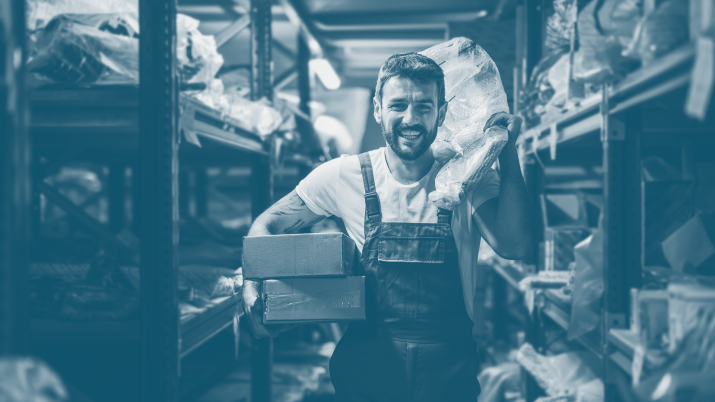 A tattooed man works in a small business in the stock room 