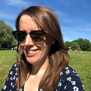 Jo sitting in a park smiling at the camera