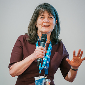 Karen Holford giving a speech while holding a microphone.