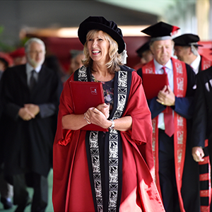 Professor Liz Barnes walking in her academic dress