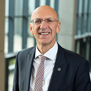 Professor Malcolm Press standing in a modern university building.