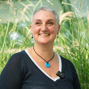 Dr Lorna Anguilano standing in a field and smiling