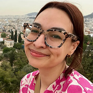 Rowan smiling in front of a leafy city backdrop